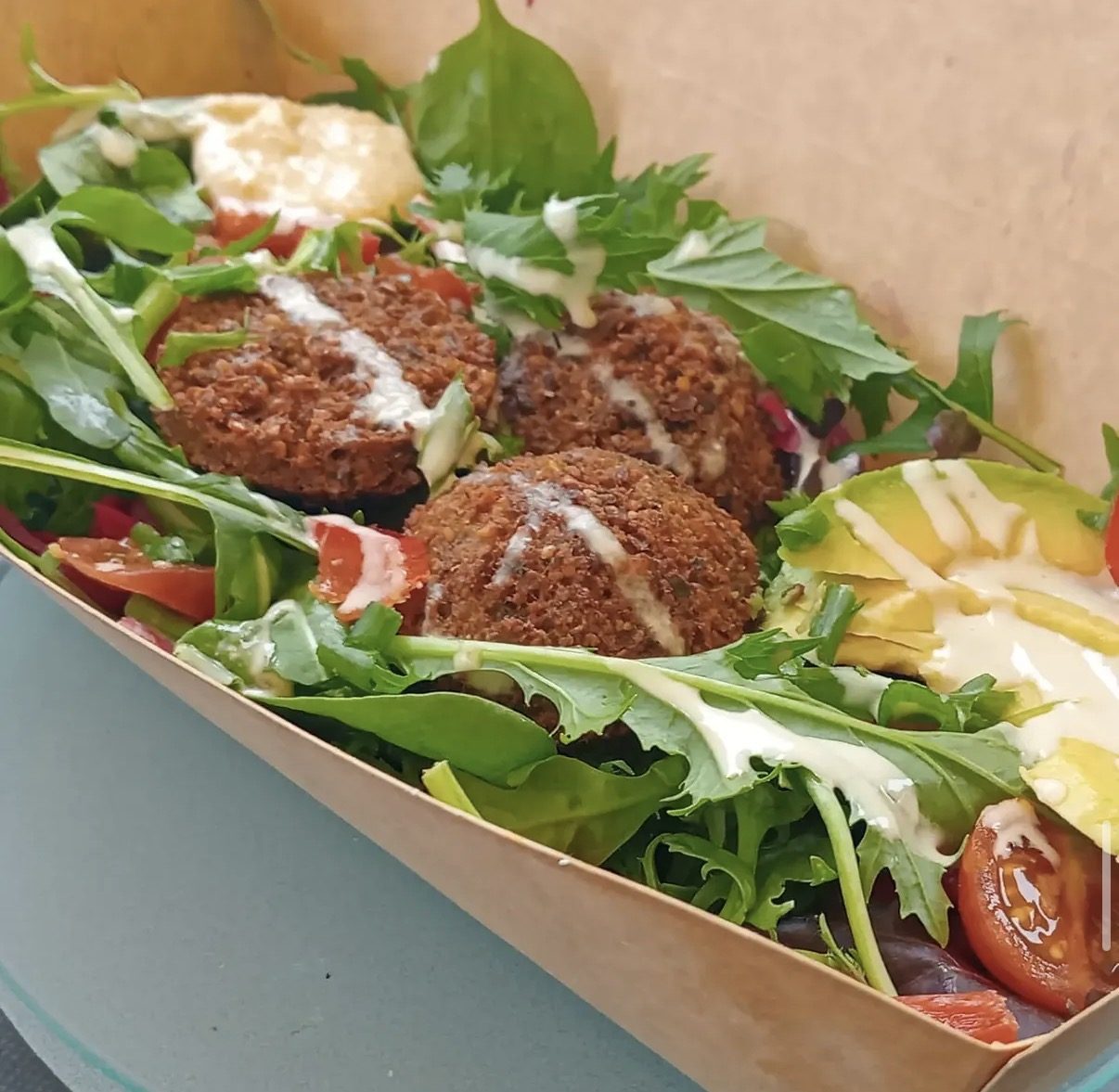 Fresh falafel box with salad, herbs and crisp falafel served at a stall