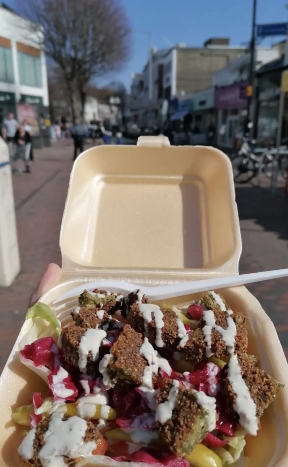 Open Falafel Box meal served outdoors with salad and sauce